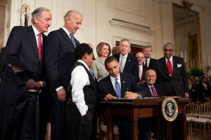 President Barack Obama signing the ACA into law Photo Credit: Wikimedia
